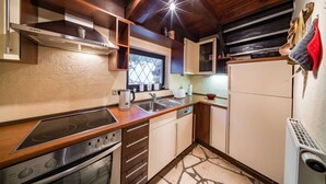 A compact kitchen with wooden cabinets, a built-in stove, and a window with a view. - Country Mill between Moselle and Hunsrück (Bernkastel-Kues)