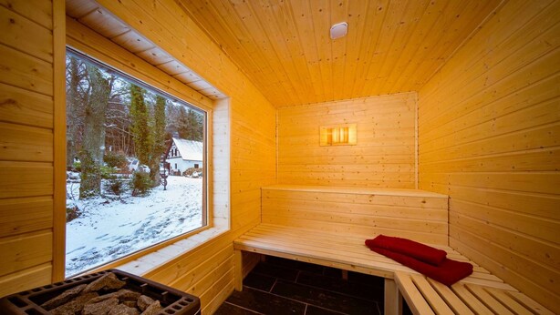 A wooden sauna room with a bench, a window, and a stone heater. - Country Mill between Moselle and Hunsrück (Bernkastel-Kues)