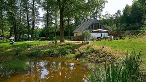 A house with a sloped roof, surrounded by a lush garden and a small pond. - Country Mill between Moselle and Hunsrück (Bernkastel-Kues)