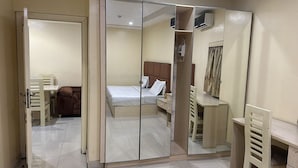 Un dormitorio con cama, escritorio, silla y armario.