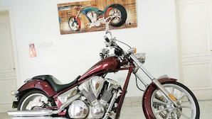 Una motocicleta vintage con detalles cromados, asiento negro y un faro grande.