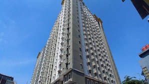 Un edifici residencial alt amb nombrosos balcons i un disseny arquitectònic modern.