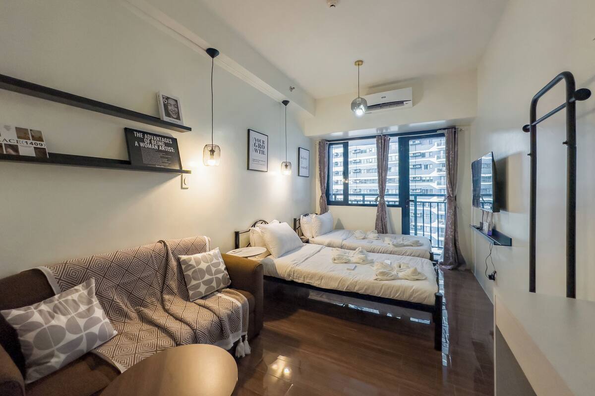 Un dormitorio moderno con cama, sofá y televisor.