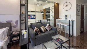 Een moderne woonkamer met een bank, salontafel en een televisie waarop een film draait.