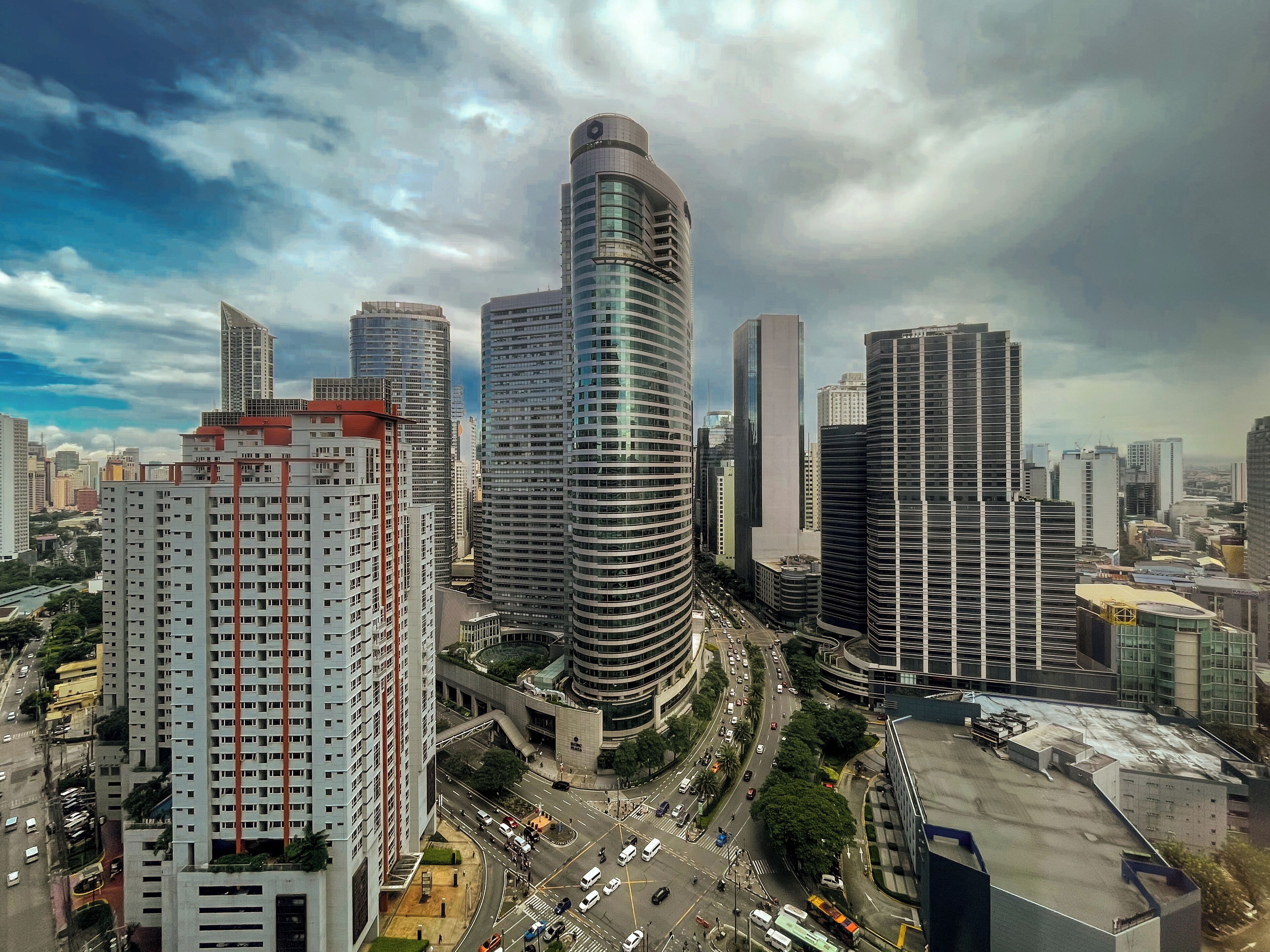 A high-rise urban area with modern buildings, a busy intersection, and a clear sky.