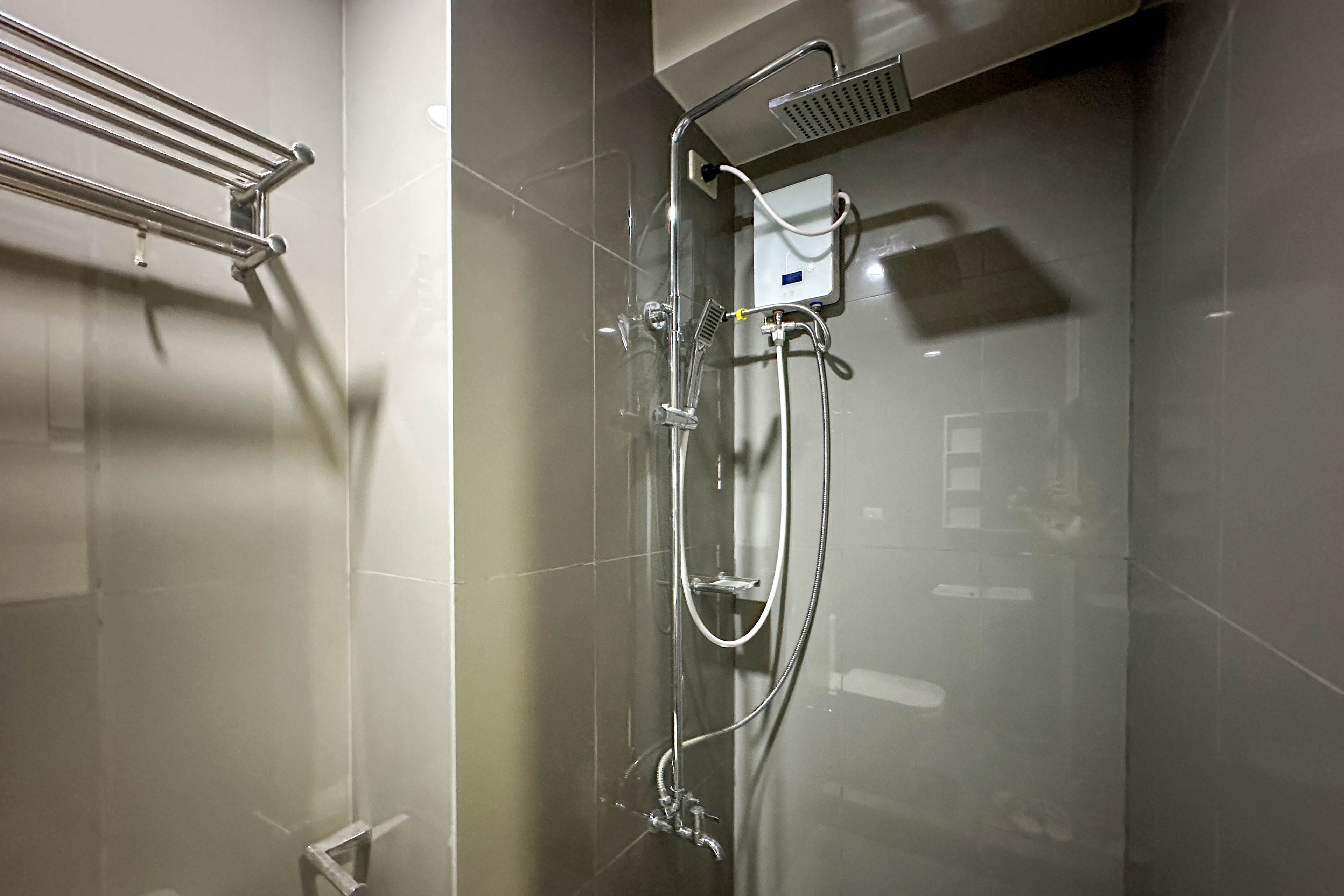 A modern shower with a glass enclosure, chrome fixtures, and a handheld showerhead.