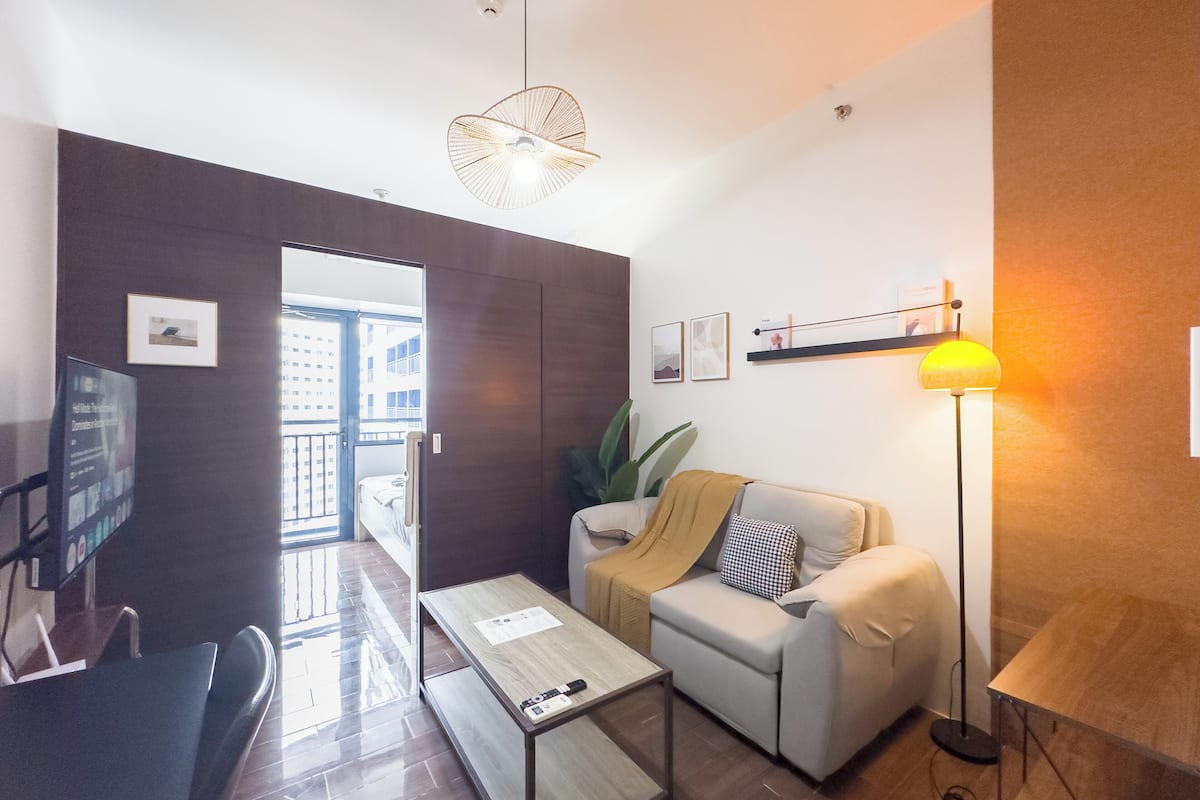 Una sala moderna con un sofá, una mesa de centro y una lámpara colgante.
