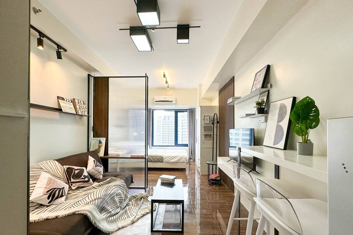 Una sala de estar moderna con un sofá, una mesa de centro y una estantería.