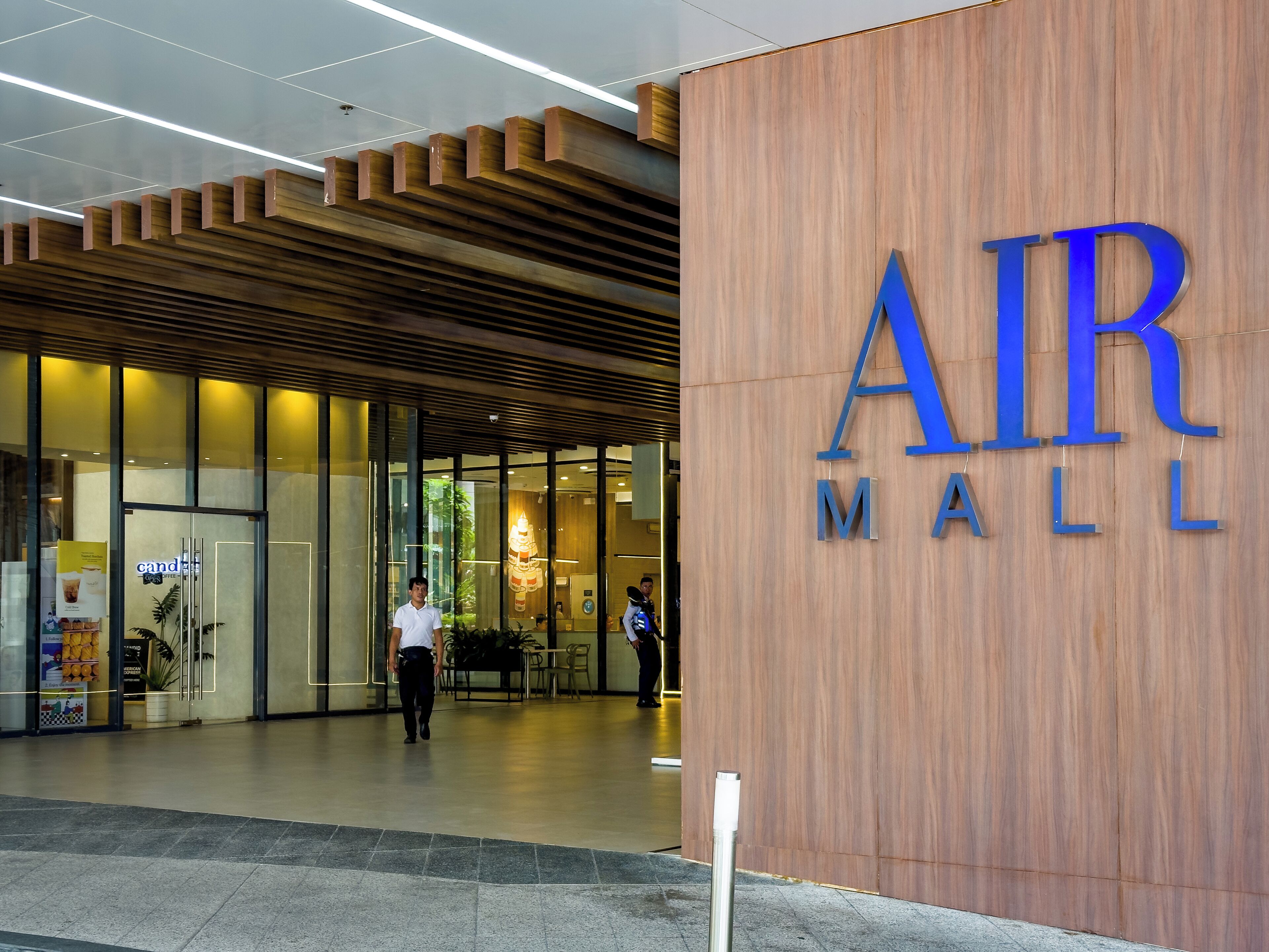 The entrance to AIR MALL with a modern wooden facade and glass doors.