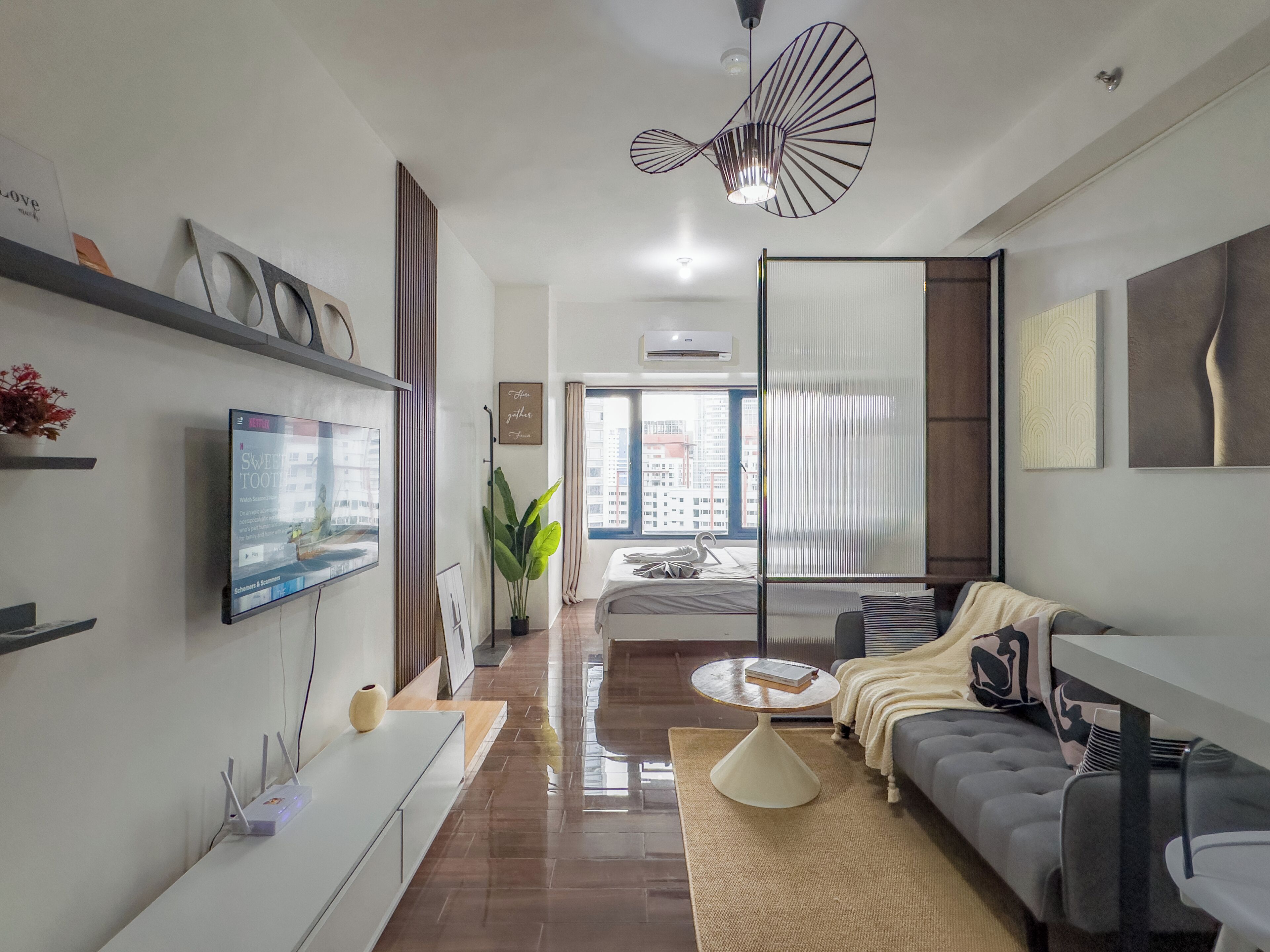 A modern living room with a sofa, a coffee table, and a TV mounted on the wall.