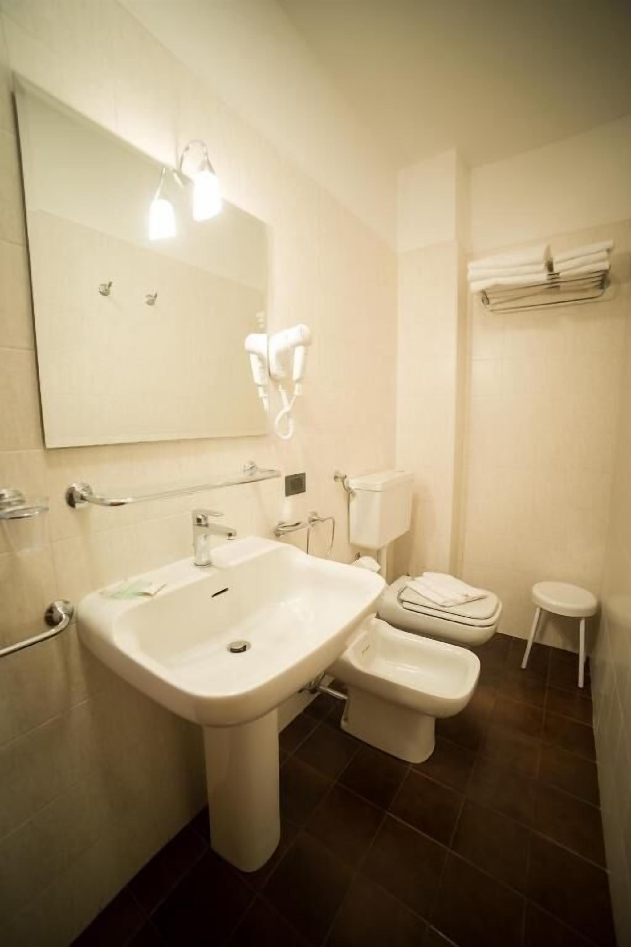 Baño con lavamanos, inodoro y espejo.