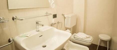 Baño con lavamanos, inodoro y espejo.