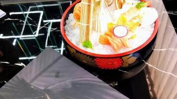 A sushi dish on a black table with a 'Kyoto Sushi Restaurant' placard.