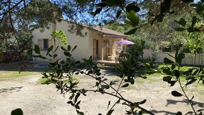 Una casa con patio, una puerta y un paraguas morado.