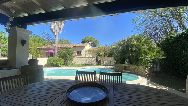 Una terraza de madera con mesa de billar y jacuzzi.