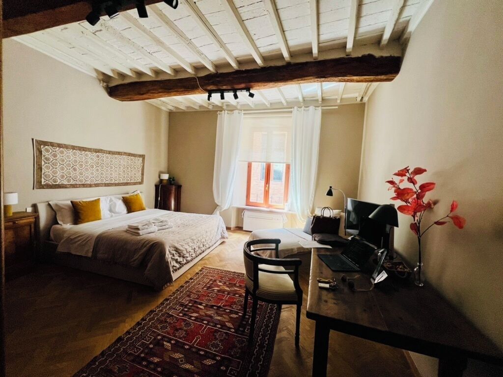 The master bedroom is large, has a chaise lounge and a desk. 