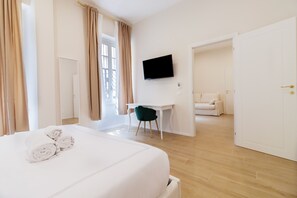 A hotel room with a bed, a desk, a TV, and a view of the outside. - Charme & Chic Nazionale (Rome)