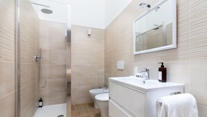 A modern bathroom with a glass shower enclosure, a white sink, and a toilet. - Charme & Chic Nazionale (Rome)