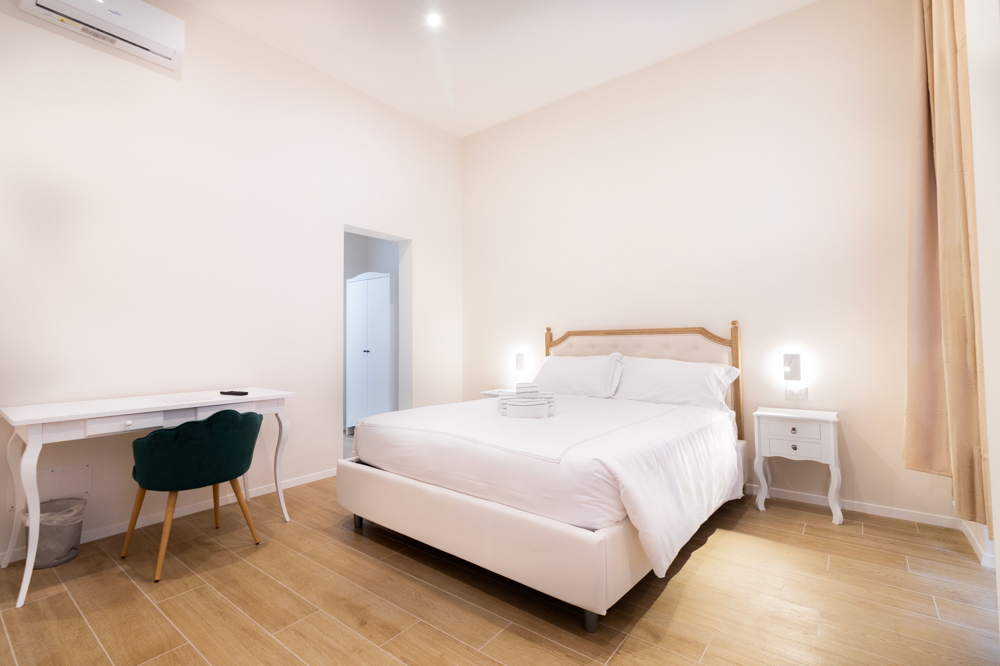 Un dormitorio con cama, escritorio, silla y mesita de noche.