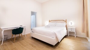 A bedroom with a bed, a desk, a chair, and a nightstand. - Charme & Chic Nazionale (Rome)
