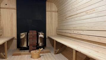 Una sauna con bancos de madera y pared de ladrillo.