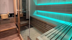 Un sauna avec des bancs en bois et une paroi en verre.