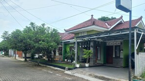 A residential building with a tiled roof, green walls, and a covered porch area. - Hotel O Homestay Koe Syariah (Sukaradja)