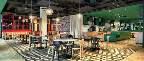 Un café moderno con suelo a cuadros, mesas y sillas de madera, y una decoración en tonos verde y rojo.