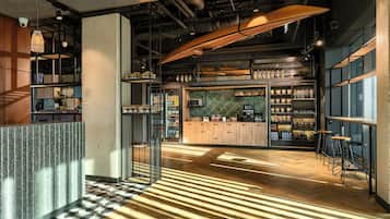 Zona de bar moderna con suelo de espiga, barra de madera y taburetes.