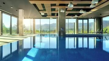 Alberca techada, alberca al aire libre y camastros