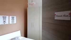A bedroom with a bed, a wardrobe, and a sign indicating a 'Romantic Room'.