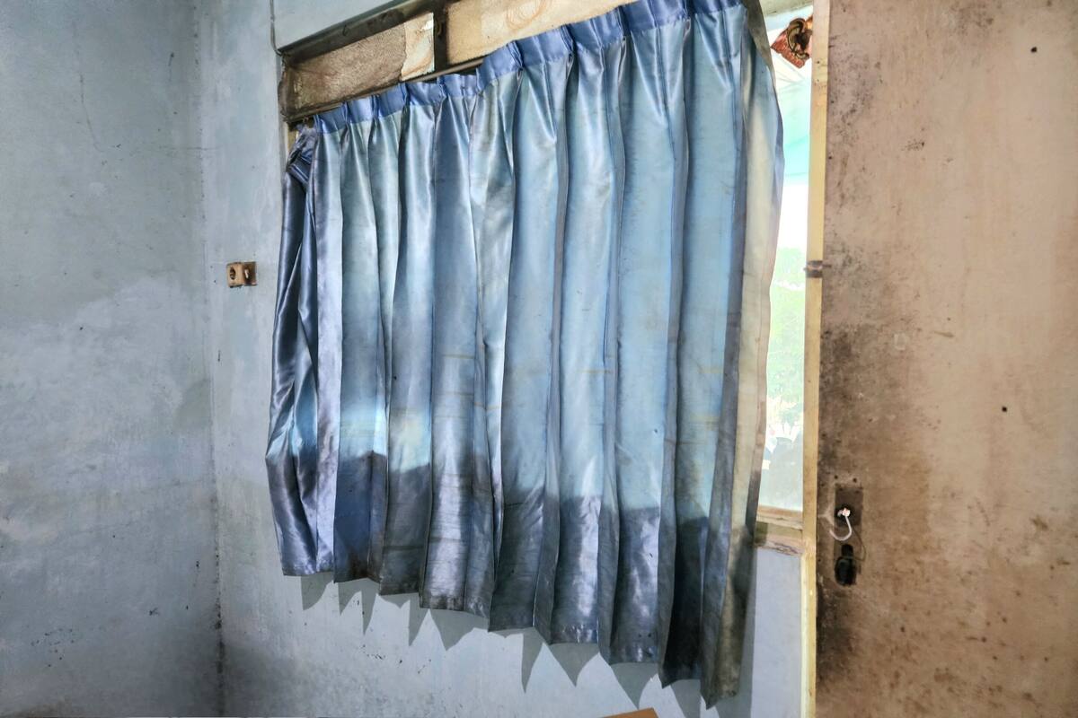 A room with a window covered by a blue curtain.
