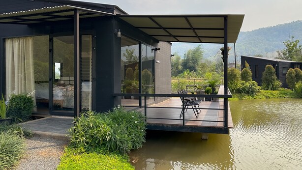 A modern house with a glass door, a covered outdoor area, and a pond. - Na Muen See  (Samoeng)