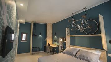 A bedroom with a bed, a desk, and a bicycle mounted on the wall.