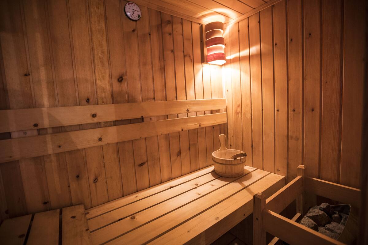 En træsauna med bænke og en træspand.