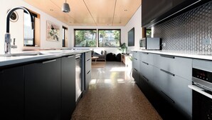 Una cocina moderna con una isla central, armarios negros y un microondas en la encimera.