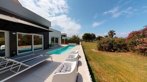 Une maison moderne dotée d’une piscine, d’un espace extérieur aménagé et d’un jardin bien entretenu.
