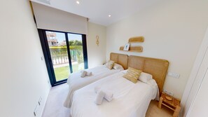 Une chambre avec deux lits, un balcon et une vue sur l’extérieur.