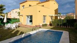 A yellow building with a swimming pool, white outdoor furniture, and a pergola. - Seraph by ON Travel (Oliva)