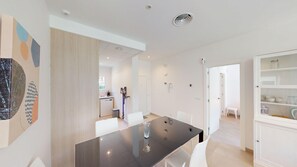 A modern kitchen with white cabinets, a dishwasher, and a sink.
