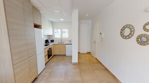 Een moderne keuken met houten kastjes, een magnetron en een koffiezetapparaat.