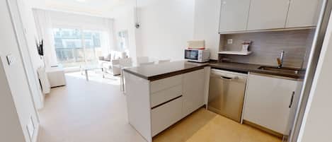 Una cocina moderna con microondas, lavaplatos y fregadero.