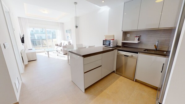 A modern kitchen with a microwave, sink, and dishwasher.