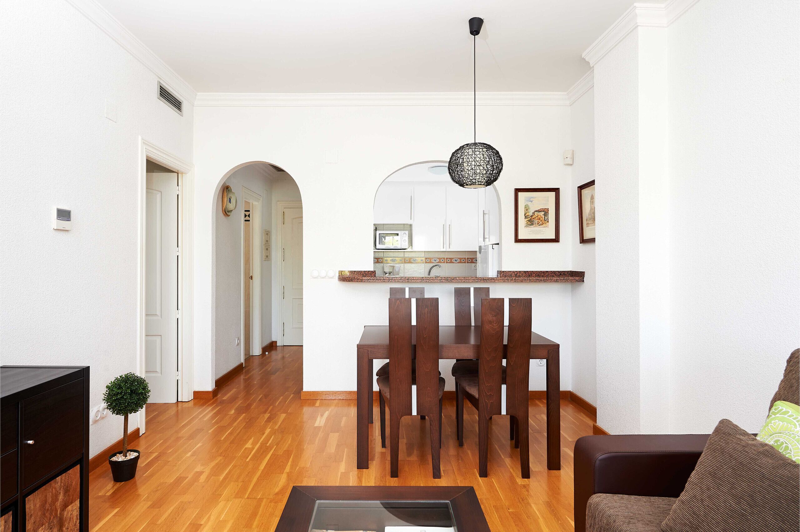 A modern apartment with a dining area, kitchen, and living room.