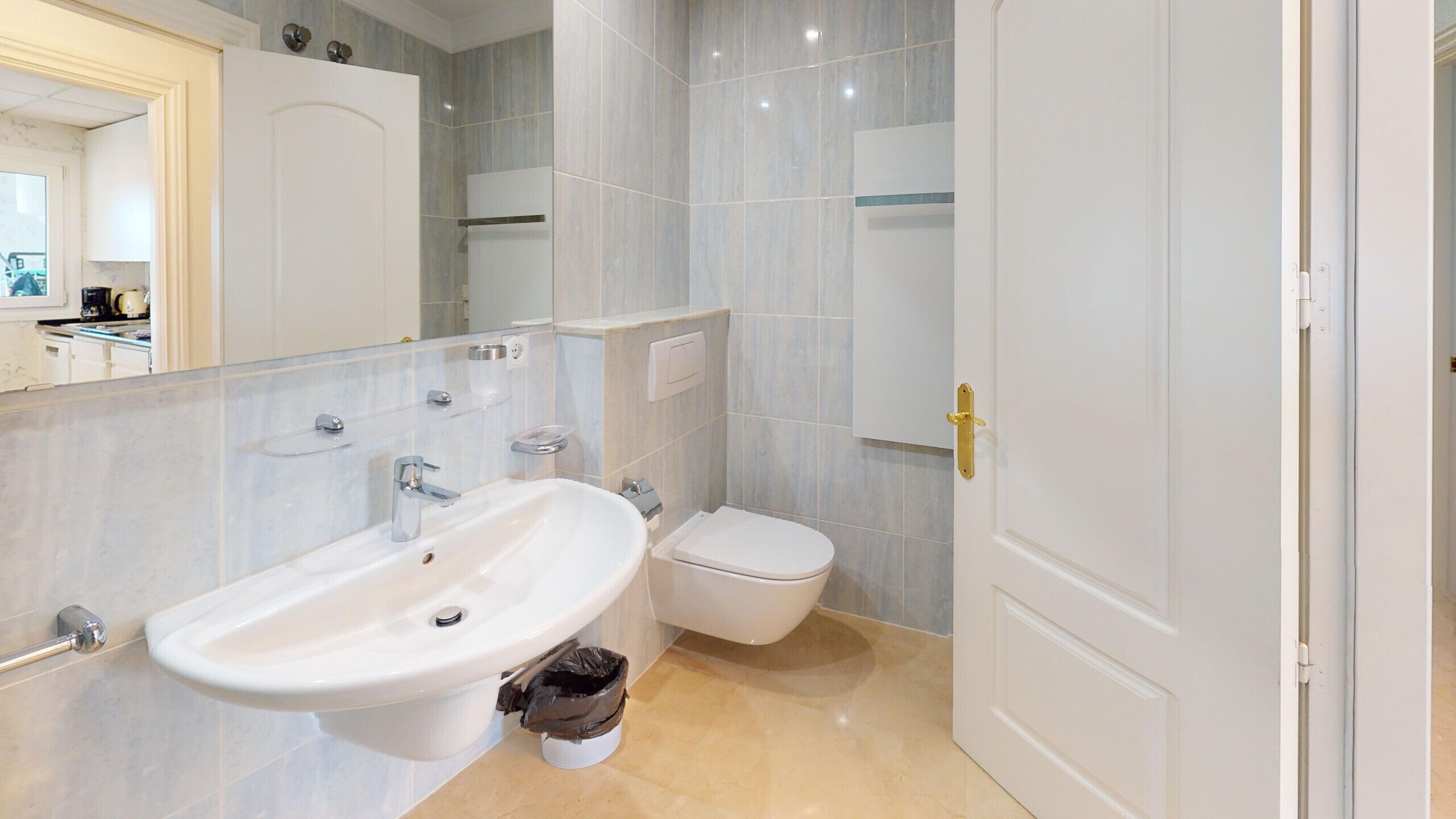 Une salle de bain avec un lavabo, des toilettes et un miroir.
