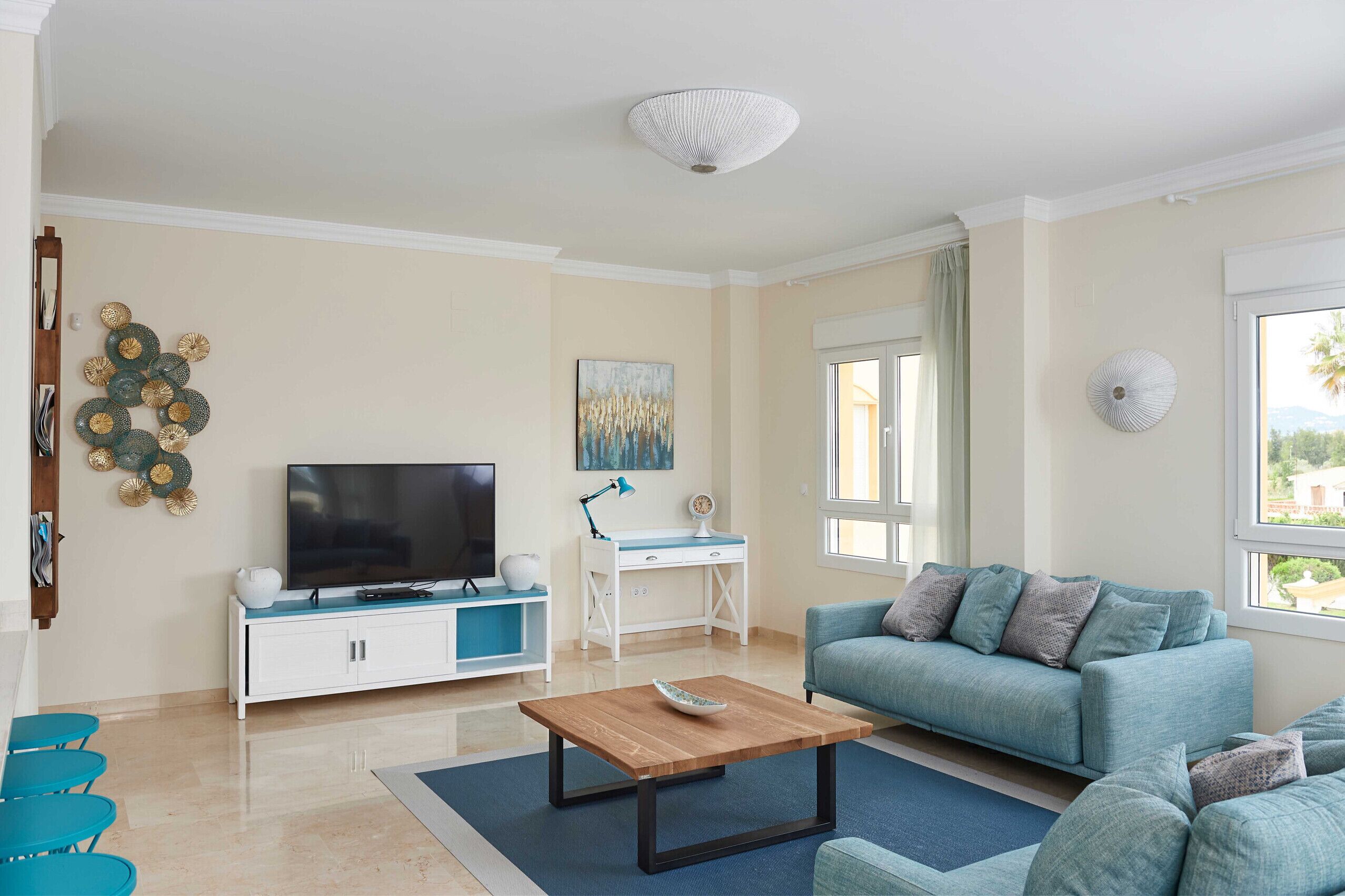 A living room with a TV, a desk, a sofa, and a coffee table.