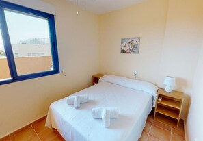A hotel room with a bed, a nightstand, a lamp, and a window. - Penthouse in Denia (Denia)