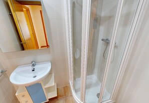 A bathroom with a sink, mirror, and glass shower enclosure. - Penthouse in Denia (Denia)
