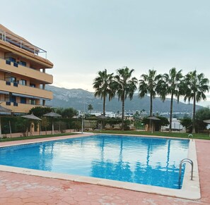 A swimming pool with a clear view of a multi-story building in the background. - Penthouse in Denia (Denia)