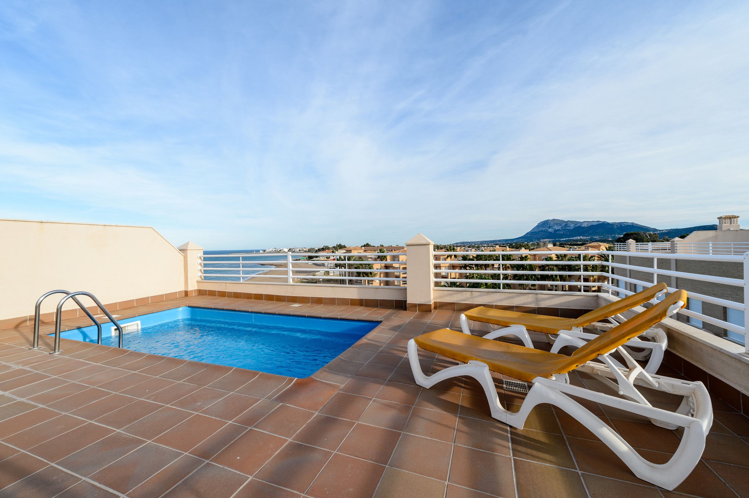 Una piscina en la azotea con vistas al mar y a las montañas.